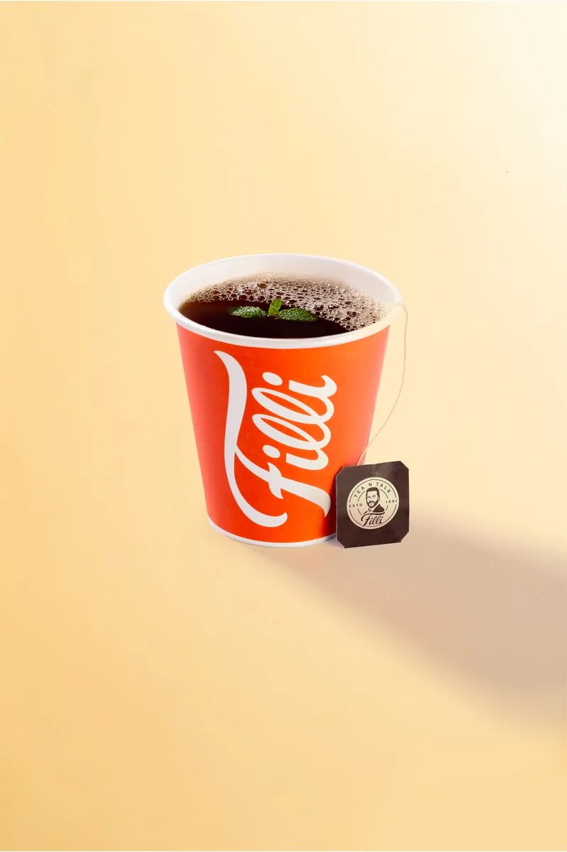 Orange FiLLi cup of dark tea with a tea bag tag