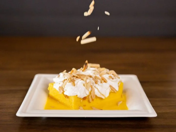 Zafran milk cake topped with cream and almonds