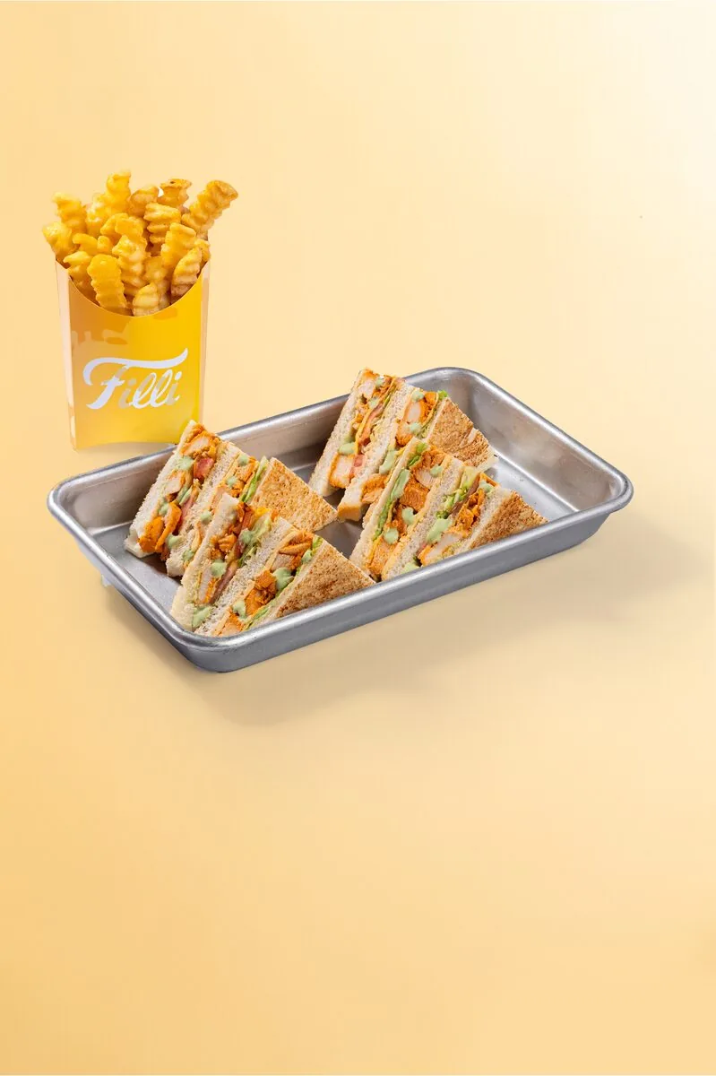 Chicken dynamite club sandwich triangles served with fries